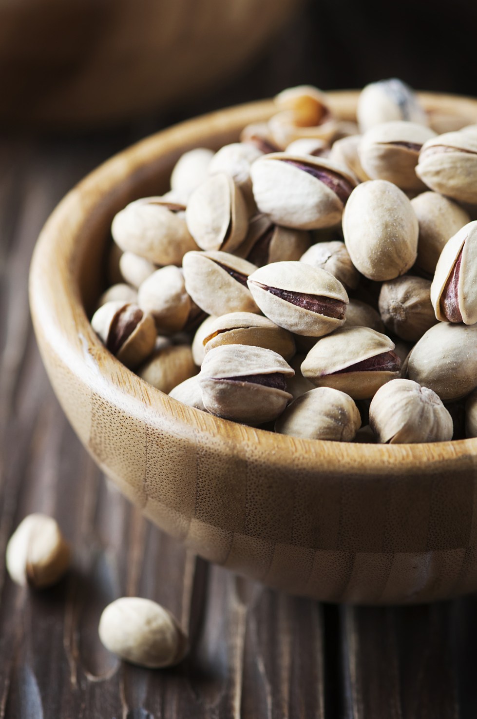 Salt pistachio nuts in the wooden bowl